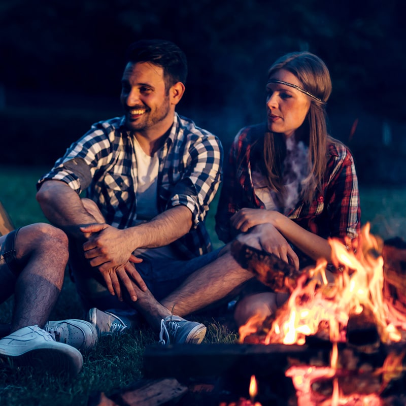 image of man and woman around camp fire